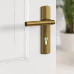 Axa Binnendeurbeslag Curve Brons PC72 met profiel cilinder gemonteerd op witte deur